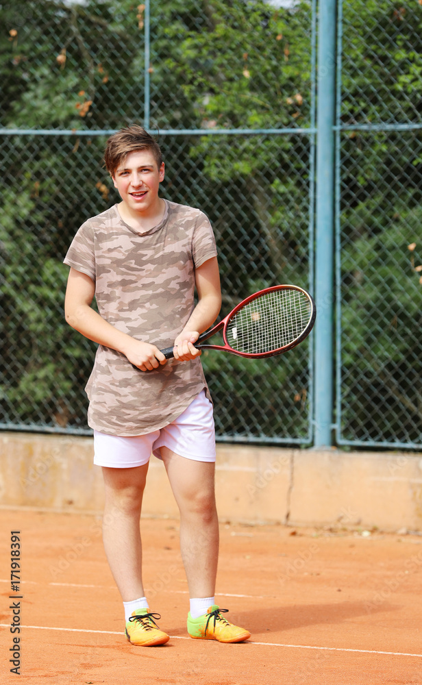 Smilling young boy on tennis court
