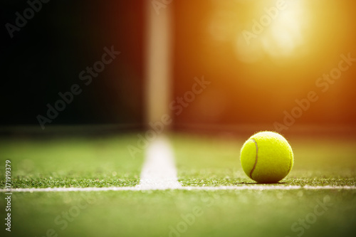 soft focus of tennis ball on tennis grass court with sunlight © kireewongfoto