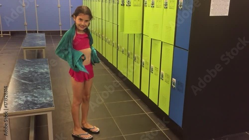 girl teenager in the locker room wipes himself with a towel. booths for changing clothes after slow motion video the pool