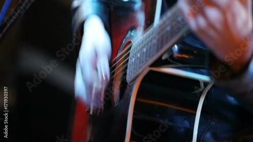 Woman's hands playing acoustic guitar on concert