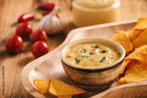 Photography Mexican cheese dip served with nachos.
