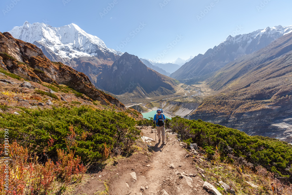 Hiker is climbig to Manaslu base camp in highlands of Himalayas on Manaslu circuit