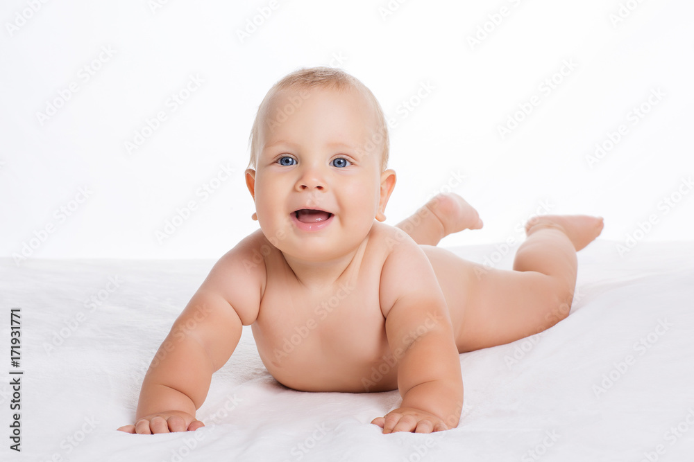 Cute smiling baby lying on towel isolated on white Cute smiling baby lying on towel isolated on white