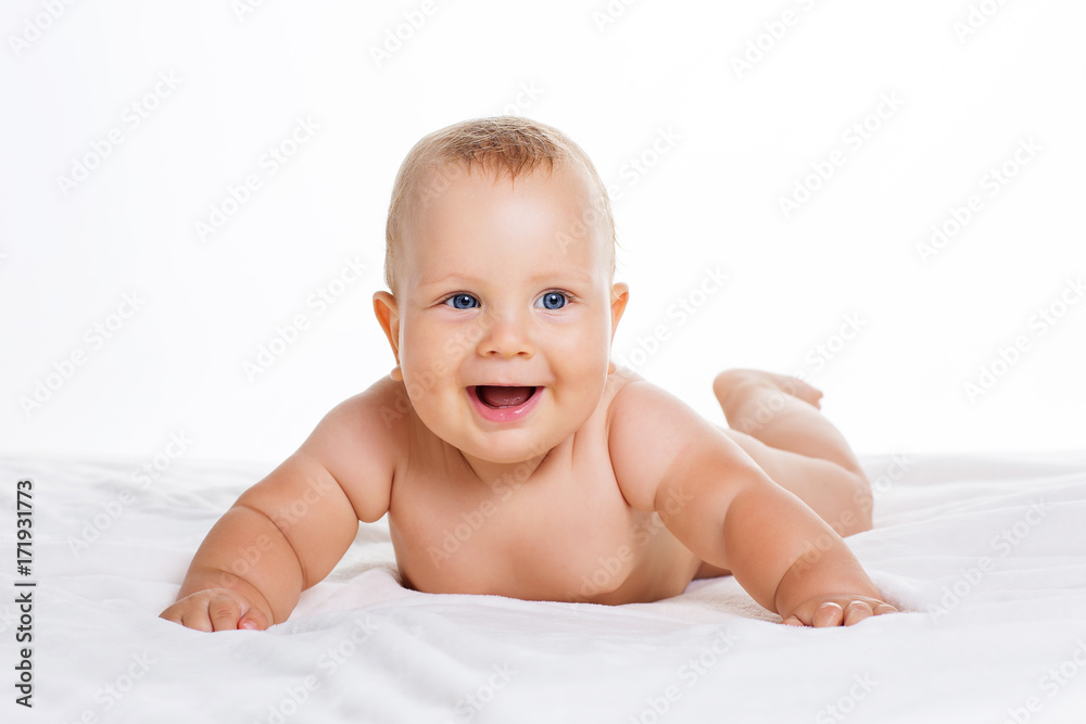 Cute smiling baby lying on towel isolated on white Cute smiling baby lying on towel isolated on white