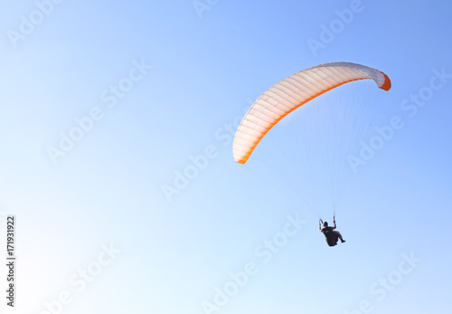 A man is flying on a paraglider in the sky