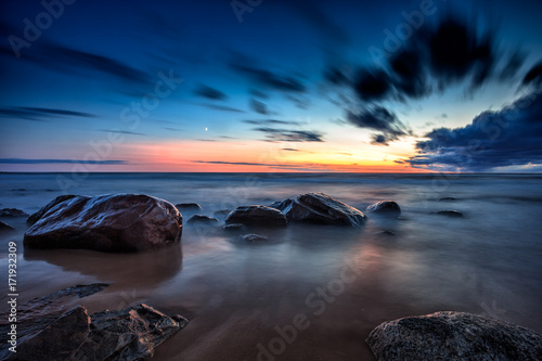 Fototapeta Naklejka Na Ścianę i Meble -  Baltic Sea sunset seascape with wet rocks. Smooth long exposure of waves
