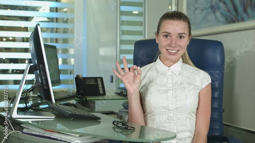 Cheerful office-worker showing thumbs up looking at camera