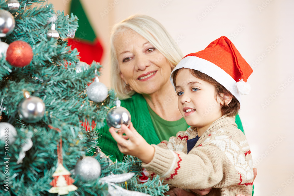 Enkel hilft Großmutter beim Schmücken vom Weihnachtsbaum Enkel hilft Großmutter beim Schmücken vom Weihnachtsbaum