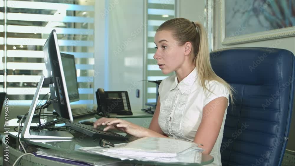 Angry office worker sitting at desk in office Angry office worker sitting at desk in office