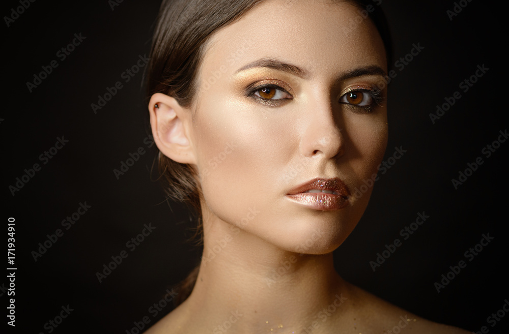 Fototapeta premium Close-up portrait of young woman with golden makeup.