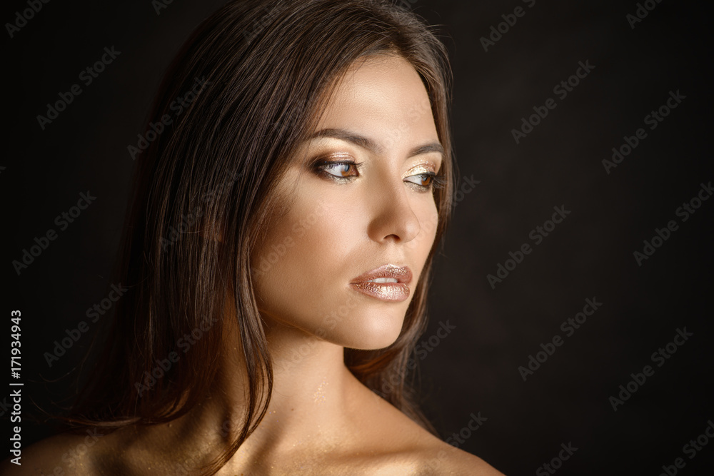 Close-up portrait of young woman with golden makeup. Close-up portrait of young woman with golden makeup.