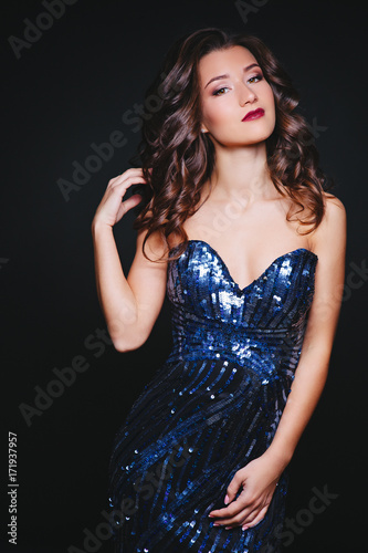Perfect hairstyle. Portrait of feminine curly women with make-up and skin. Fashion. Dress glitter