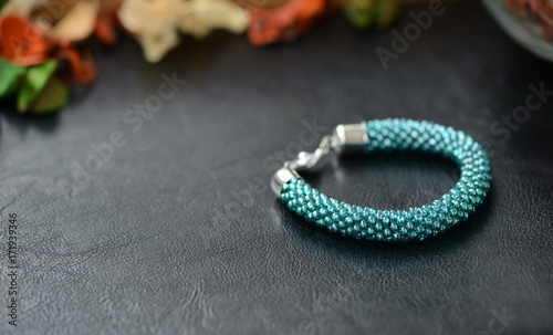 Bead crochet bracelet turquoise color on a dark background