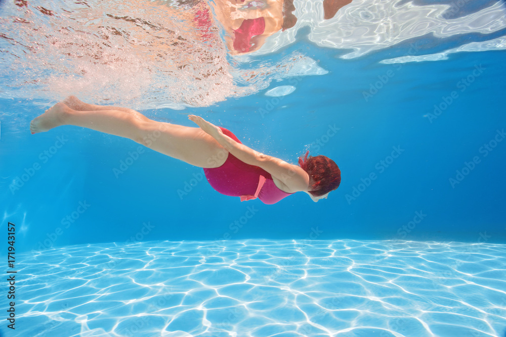 Pregnant woman swim, dive, pose underwater in swimming pool with red