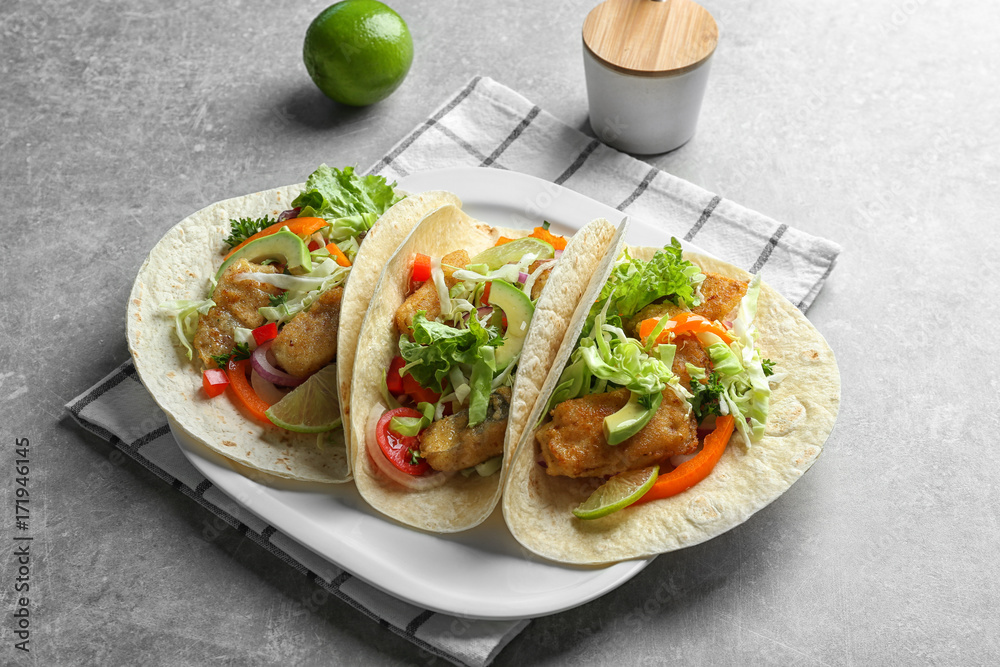 Plate with tasty fish tacos on table Plate with tasty fish tacos on table