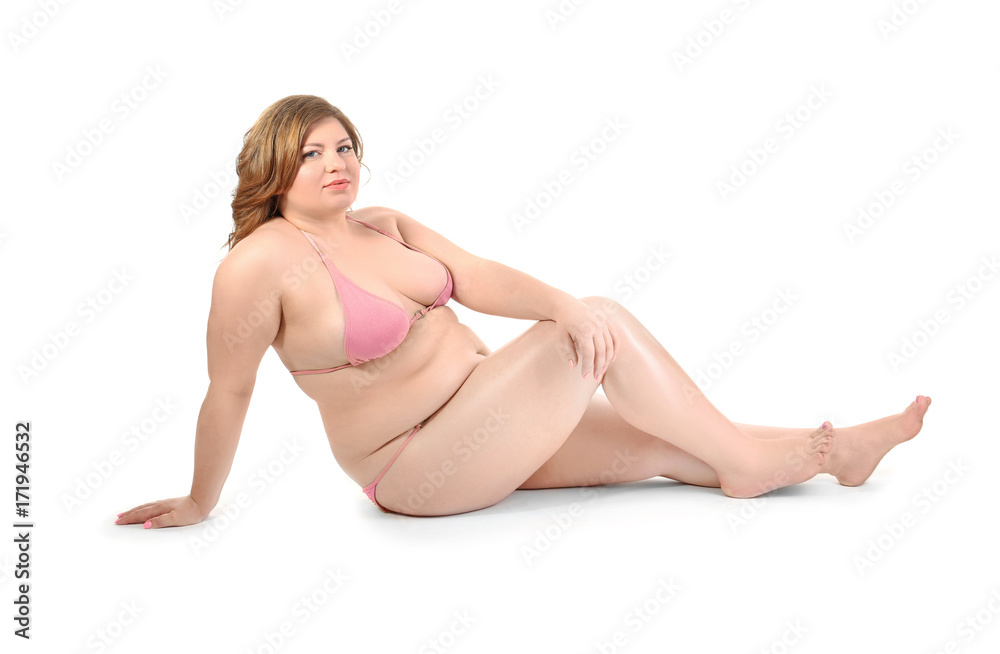 Overweight woman in swimsuit posing on white background