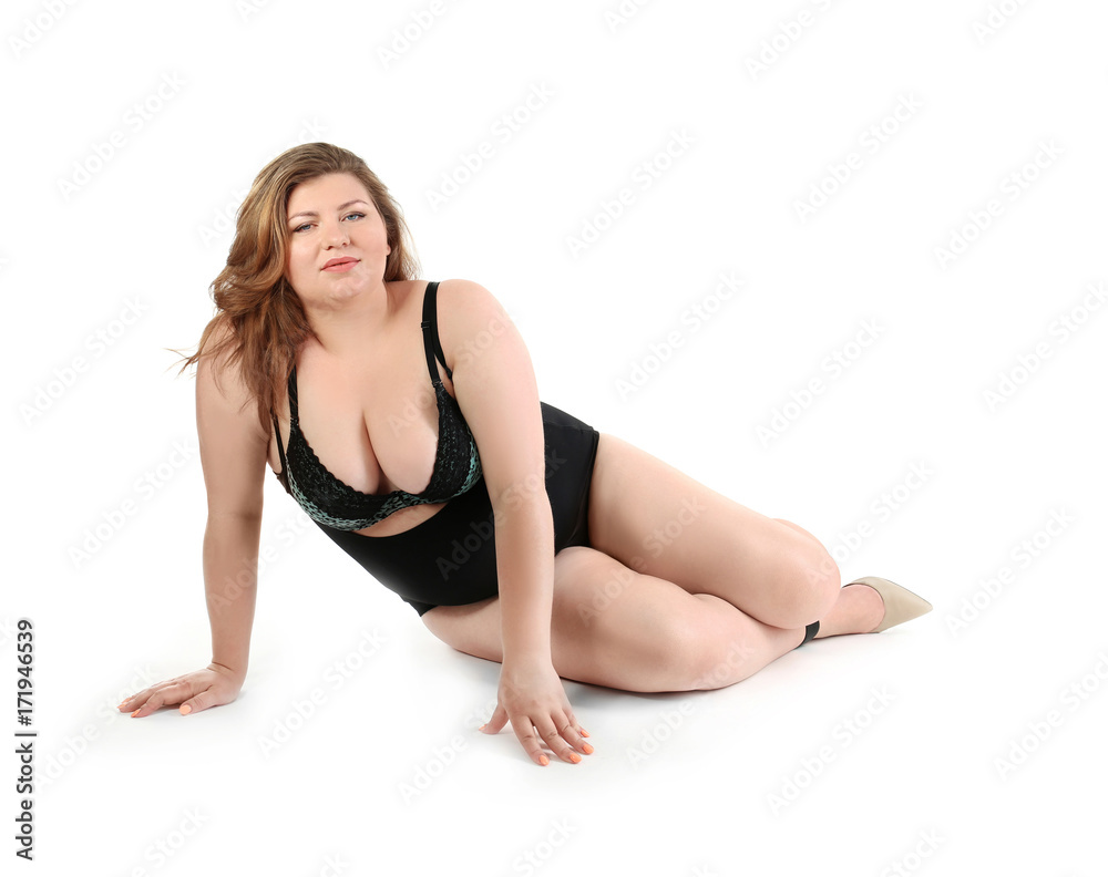 Overweight woman in beautiful underwear posing on white background