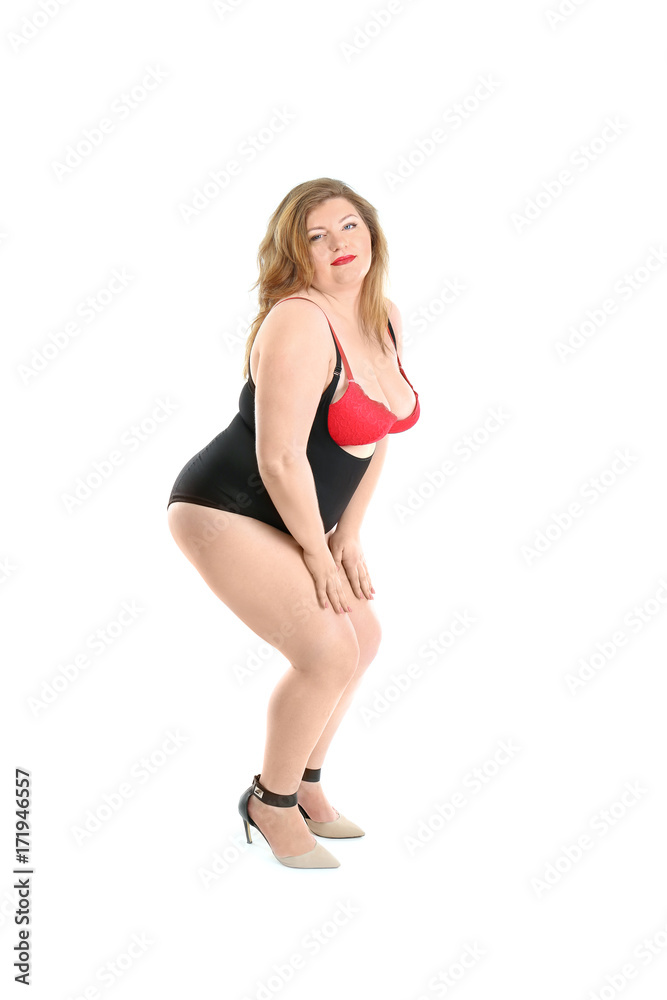 Overweight woman in beautiful underwear posing on white background