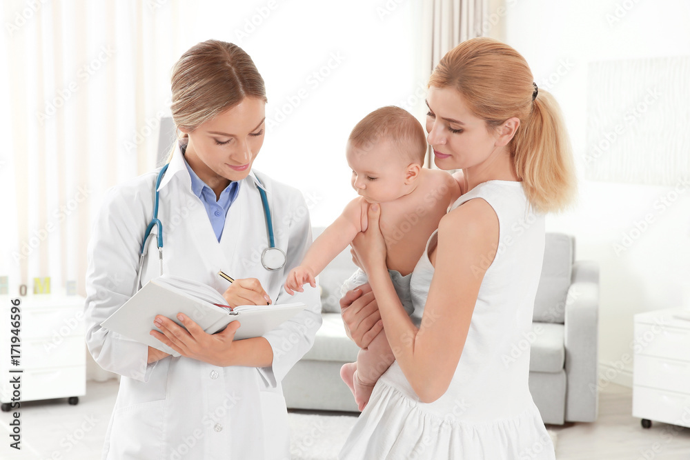 Doctor writing something in notebook and mother with baby at home Doctor writing something in notebook and mother with baby at home