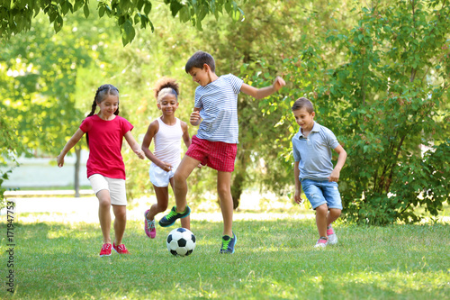 Obraz na plátně Cute children playing football in park