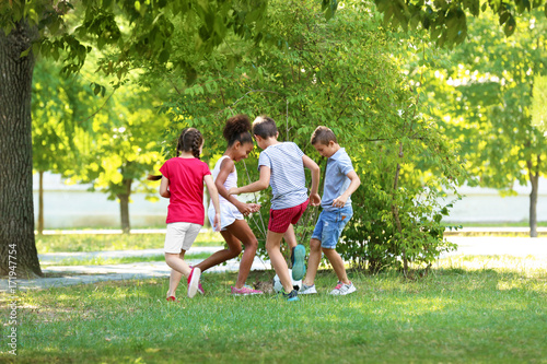 Cute children playing football in park