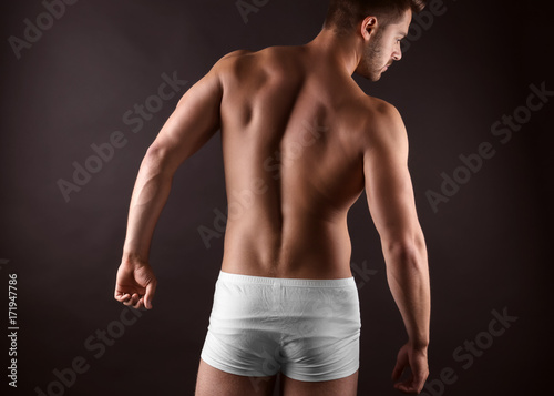 Sporty young man on dark ba...