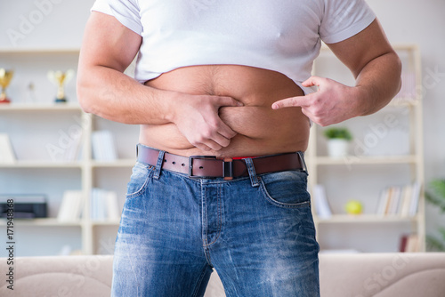 Man suffering from extra weight in diet concept