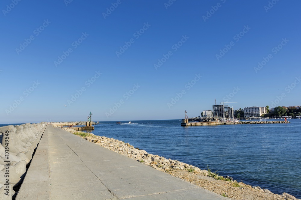 Bay view of the port town of Tomis, Constanta. Small Constanta harbour gateway view. Sea wall for protect the beach.  Breakwaters concrete tetra-pods. 