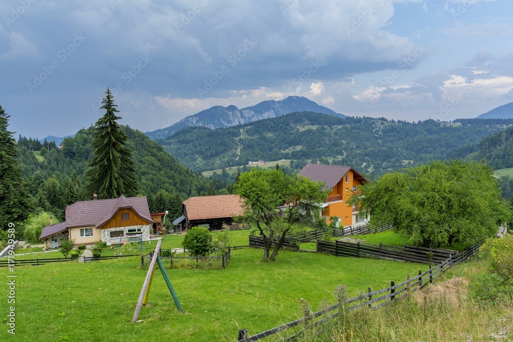 Countryside view in Transylvania. View from above of a village in the Romanian countryside. Mountains and cloudscape in the background