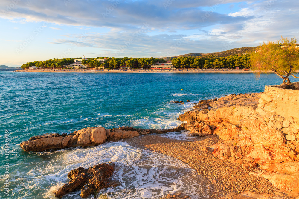 Sea waves on small beach at sunset time in Primosten town, Dalmatia, Croatia