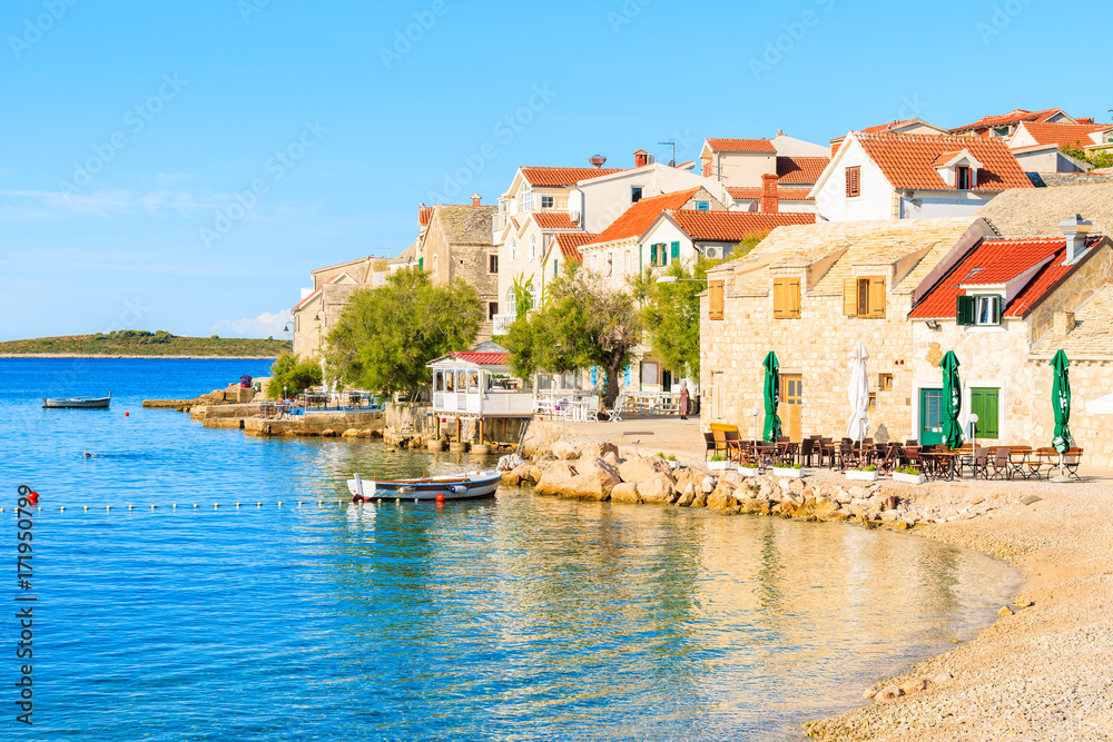 PRIMOSTEN TOWN, CROATIA - SEP 4, 2017: View of beautiful beach in Primosten old town with colorful houses, Dalmatia, Croatia.