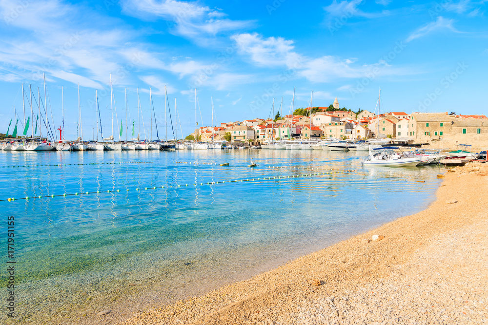 Beach with crystal clear sea water in Primosten town at early morning, Dalmatia, Croatia