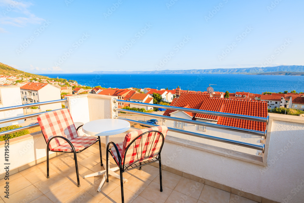 Fototapeta premium BOL TOWN, CROATIA - SEP 9, 2017: Two chairs with table on terrace of holiday apartment in Bol town, Brac island, Croatia. This island has famous port with beautiful old town.