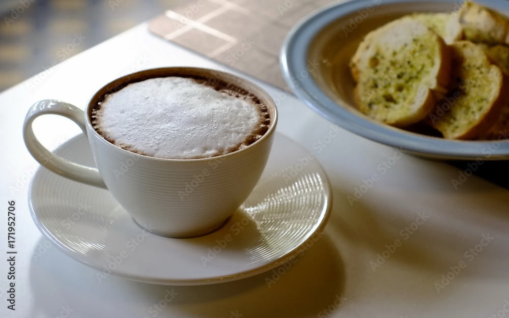 hot chocolate for a casual drink with a snack of crisp garlic bread in a coffee shop. hot chocolate for a casual drink with a snack of crisp garlic bread in a coffee shop.