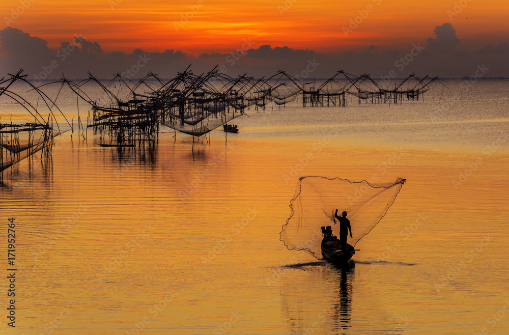fishermen throwing fishing net from his boat early morning in the