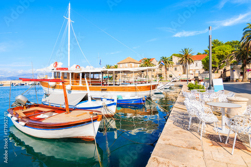 Fishing boats and chairs of local cafe bar in Sutivan port, Brac island, Croatia