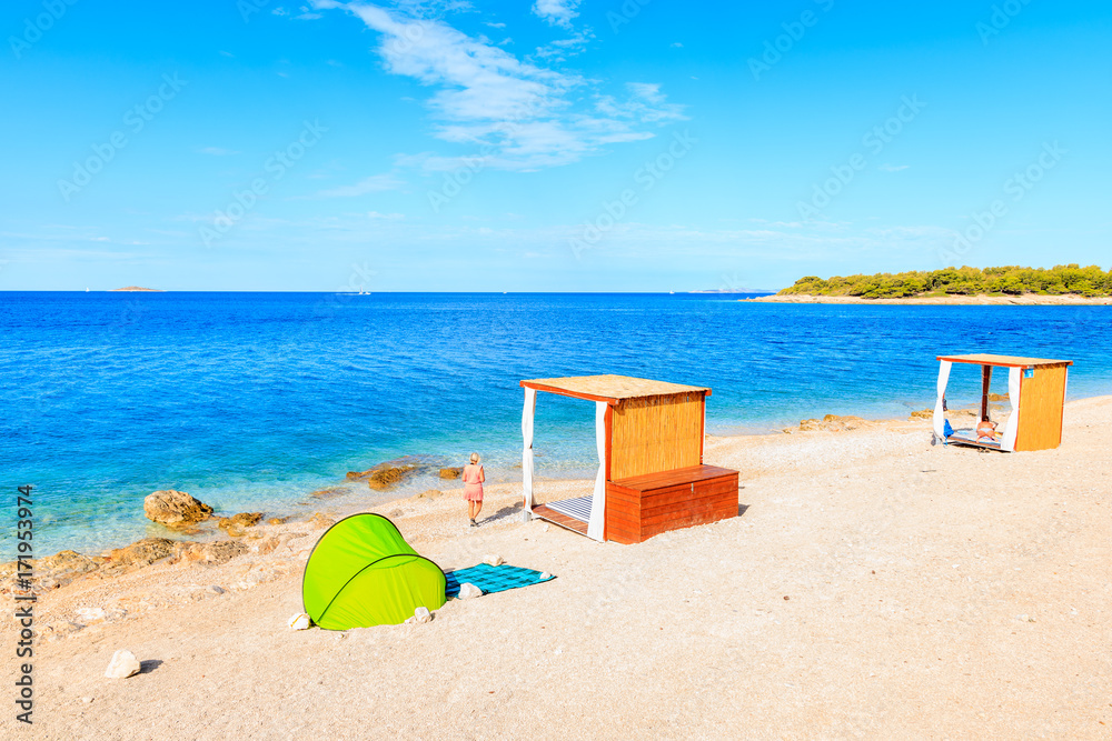 Green tent and unidentified woman on beautiful beach in Primosten town, Dalmatia, Croatia