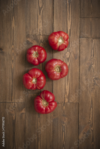 Ripe red and pink tomatoes on wooden background. Top view