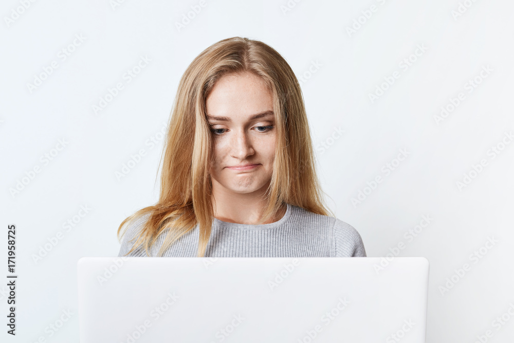 Pretty female blogger sits in front of opened laptop, writes new post, uses high-speed internet connection at home. Beautiful woman surfes social networks uses laptop computer for communication Pretty female blogger sits in front of opened laptop, writes new post, uses high-speed internet connection at home. Beautiful woman surfes social networks uses laptop computer for communication