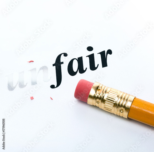 Word " unfair " and pencil with eraser close-up