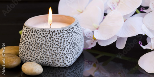 Spa candle setting with orchid and massage stones