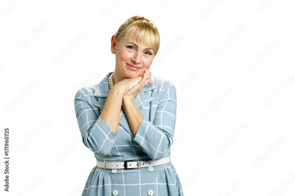Portrait of peaceful mature woman. Adult woman clasped her hands under chin isolated on white background.