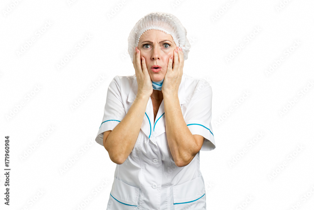 Beautiful female doctor looking shocked. Medical middle aged female doctor shocked and surprised. Woman medical professional reacting with negative shock on white background. Beautiful female doctor looking shocked. Medical middle aged female doctor shocked and surprised. Woman medical professional reacting with negative shock on white background.
