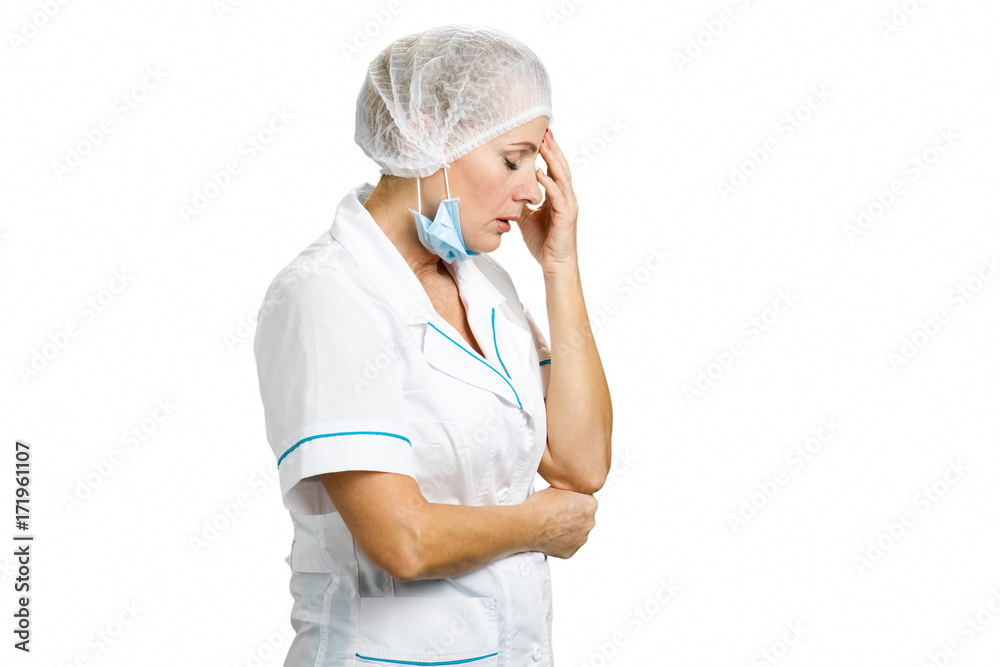 Worried and tired female doctor. Upset mature female doctor holding hand near head on white background, side profile. Worried and tired female doctor. Upset mature female doctor holding hand near head on white background, side profile.