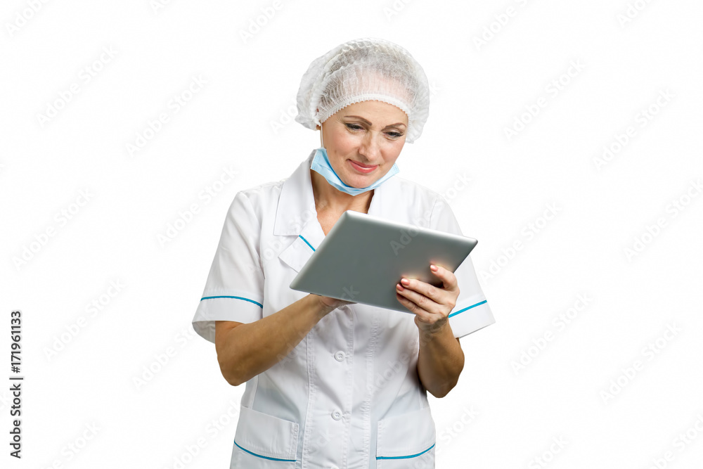 Female doctor using computer tablet. Female medical professional working on computer tablet and smiling, white background. Female doctor using computer tablet. Female medical professional working on computer tablet and smiling, white background.