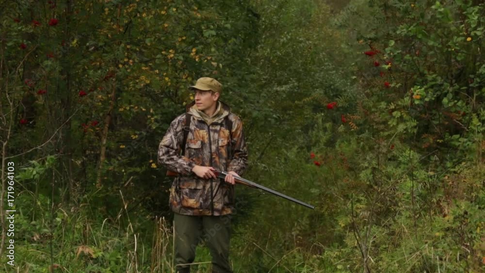 A hunter with a hunting rifle is looking for prey A hunter with a hunting rifle is looking for prey