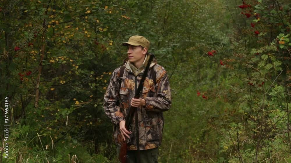 A hunter with a hunting rifle is looking for prey A hunter with a hunting rifle is looking for prey