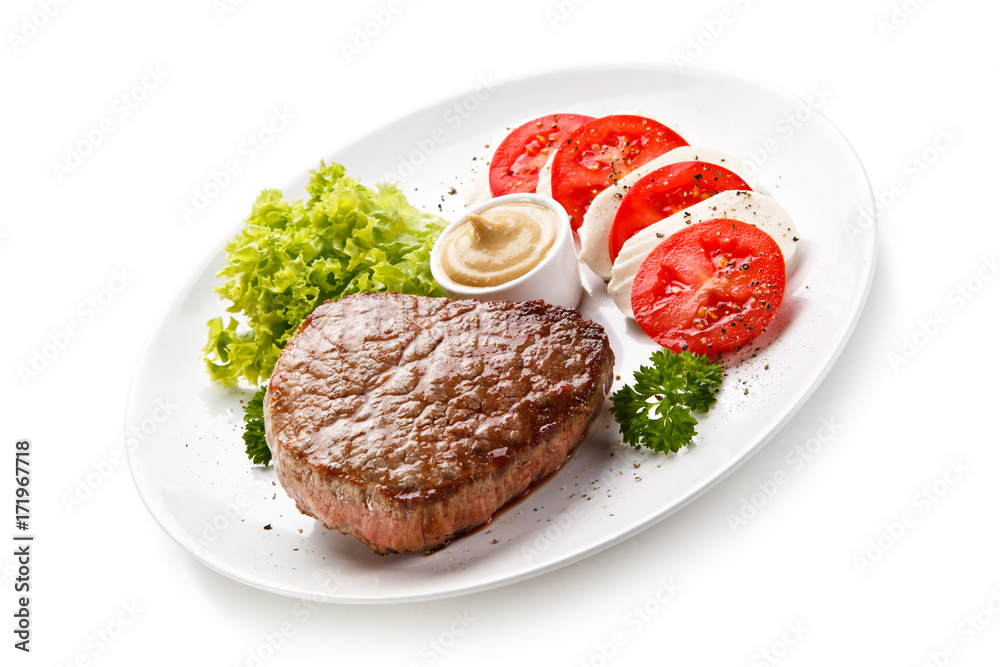 Grilled beef steak with mozzarella and vegetables on white background Grilled beef steak with mozzarella and vegetables on white background