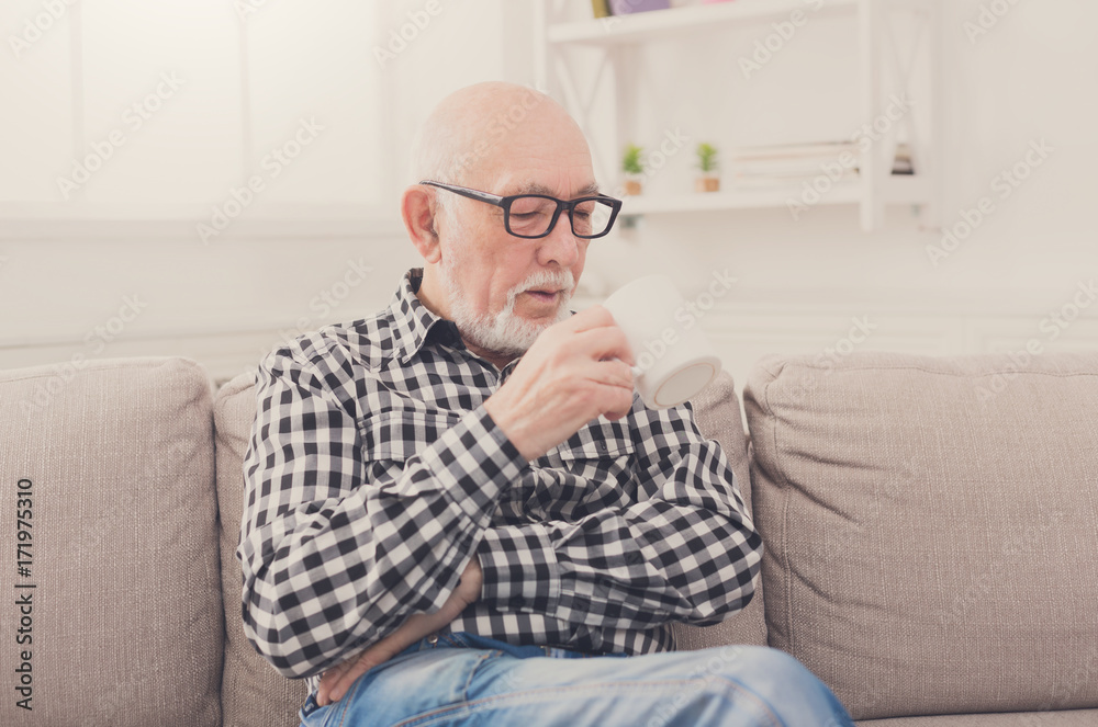 Senior man having cup of coffee in living room Senior man having cup of coffee in living room