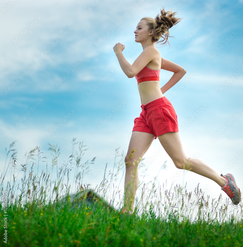Young lady running. Woman runner running through the summer park rural road. Workout in a park. Beautiful fit girl. Fitness model caucasian ethnicity outdoors. Weight loss exercise. Jogging. Young lady running. Woman runner running through the summer park rural road. Workout in a park. Beautiful fit girl. Fitness model caucasian ethnicity outdoors. Weight loss exercise. Jogging.
